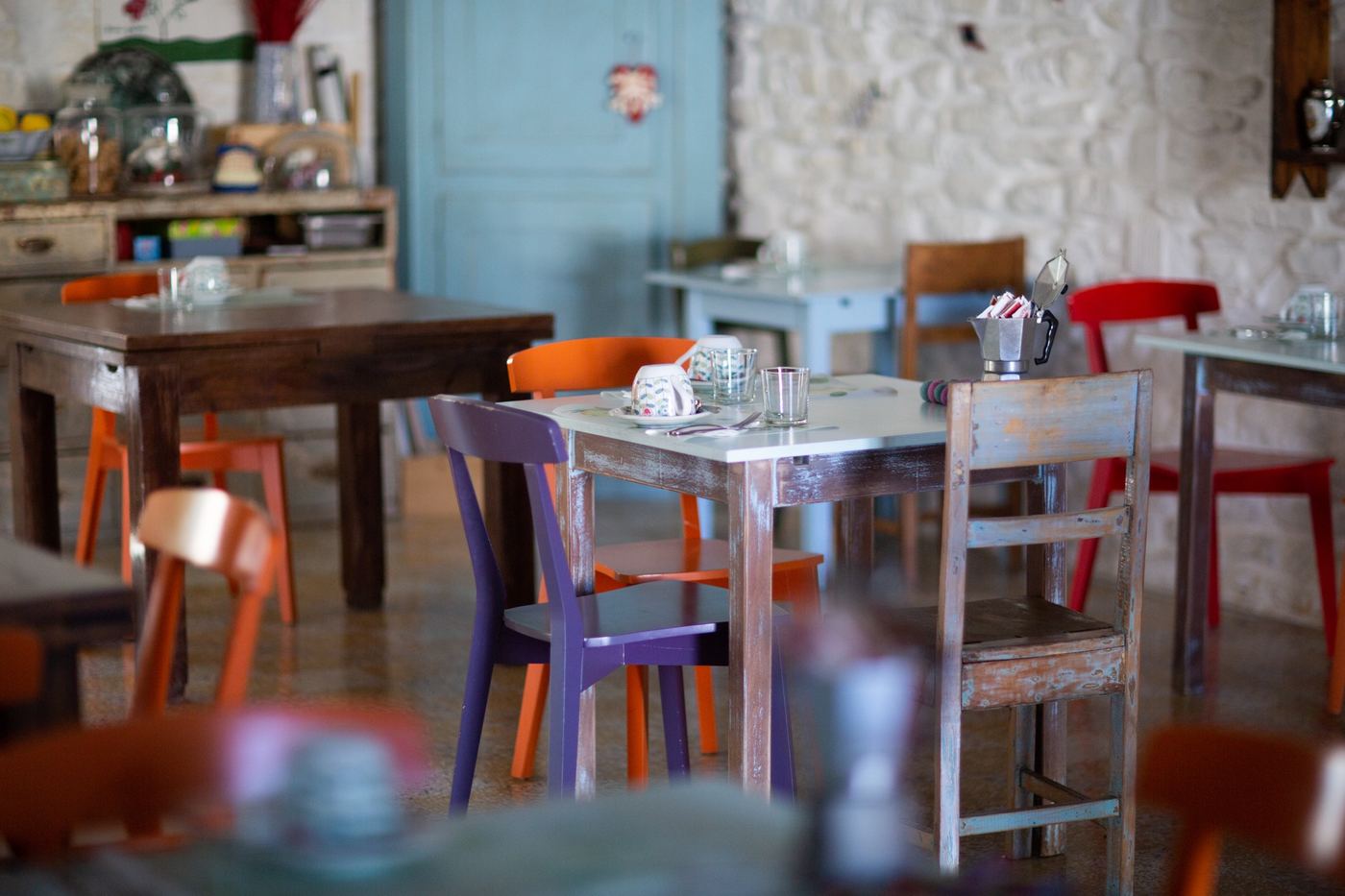 La sala colazioni, con tavoli e sedie colorate