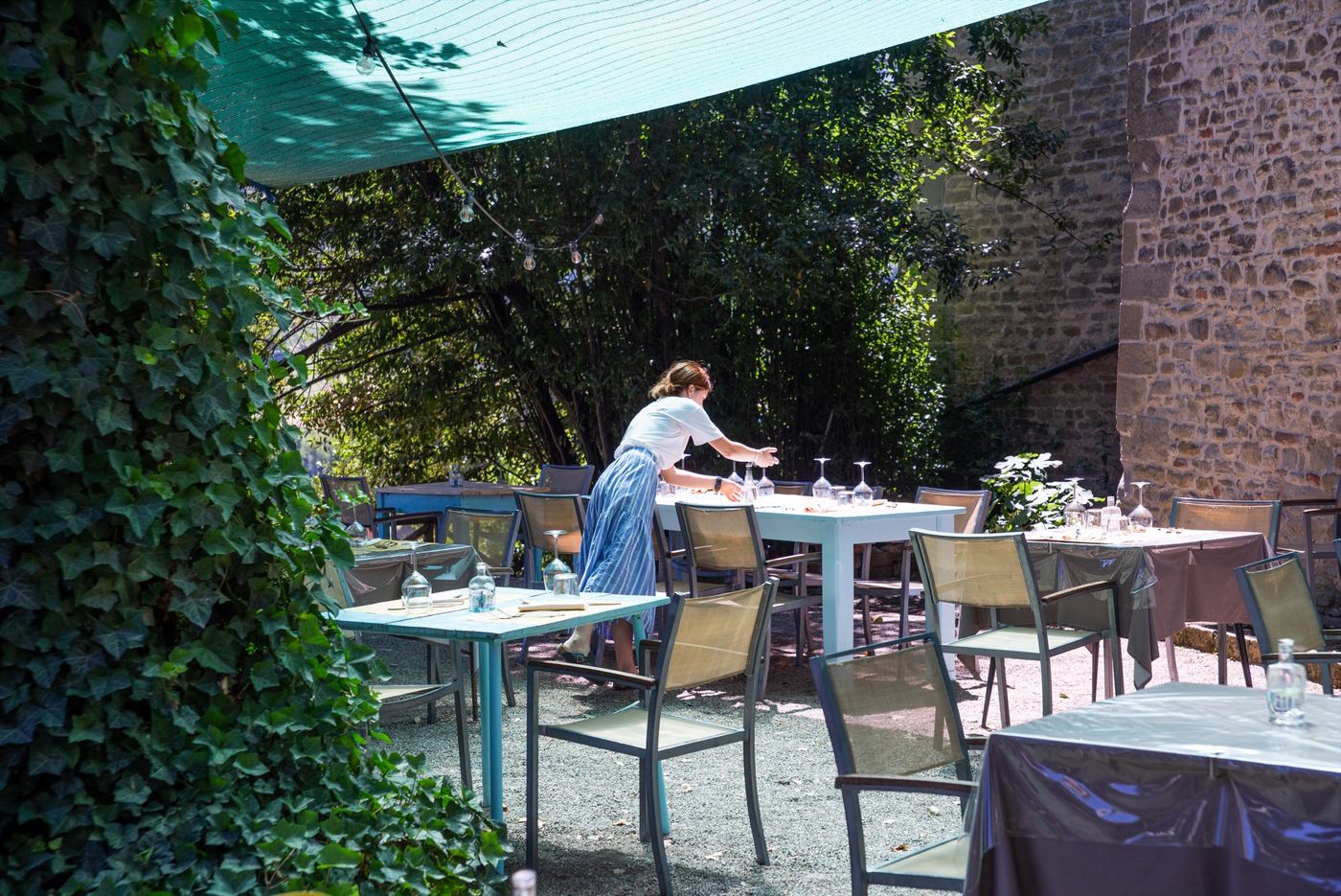 La terrazza all'aperto con i tavoli apparecchiati sotto la tenda