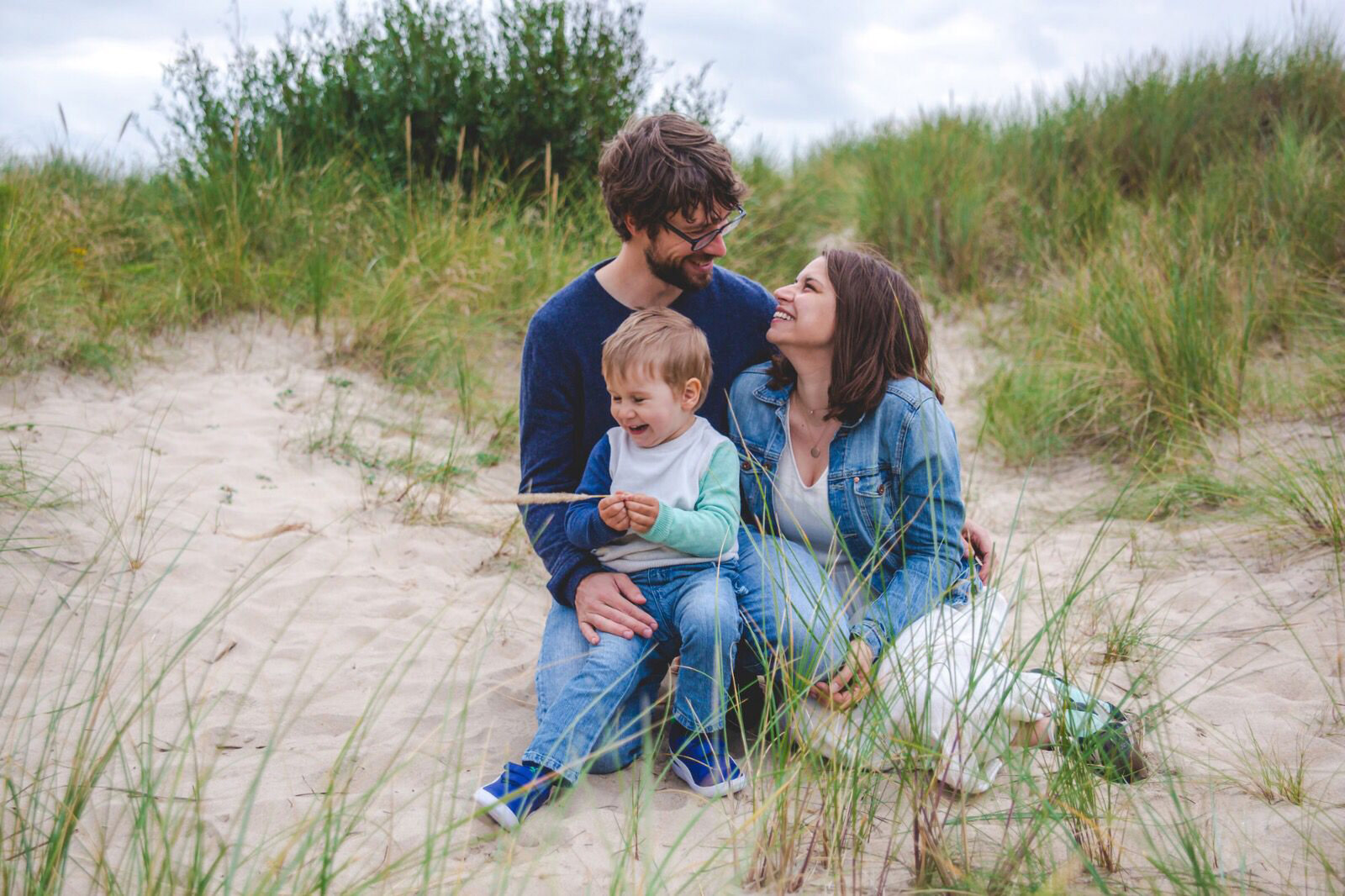 Famiglia che ride seduta tra le dune